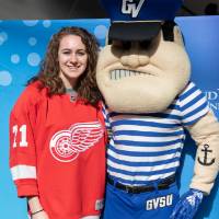 An alumna poses with Louie the Laker at the Detroit Red Wings GVSU Night